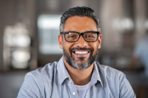 a smiling middle aged man wearing glasses