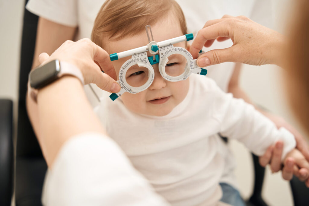 Pediatric eye doctor preparing child for visual acuity test